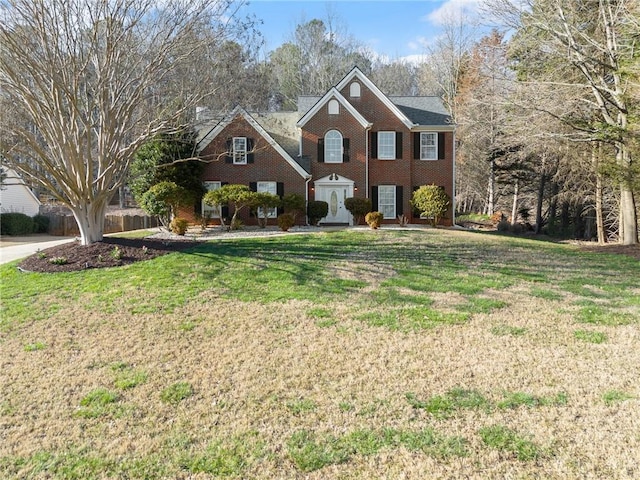 colonial home featuring brick siding and a front yard