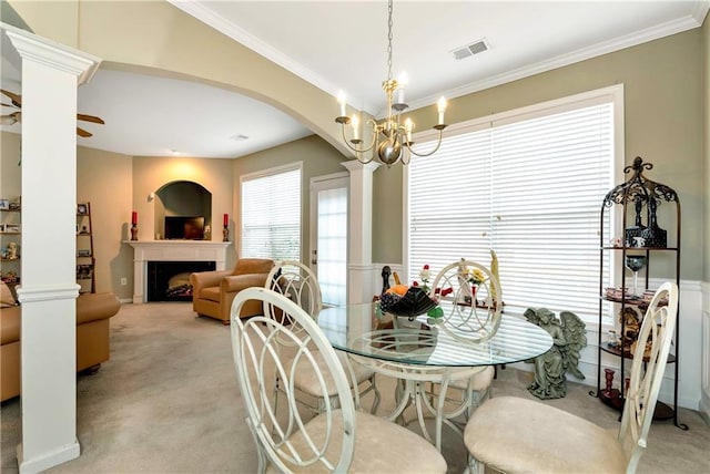 carpeted dining space featuring ceiling fan with notable chandelier and ornamental molding