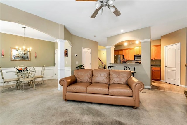 living room with ceiling fan with notable chandelier and light carpet