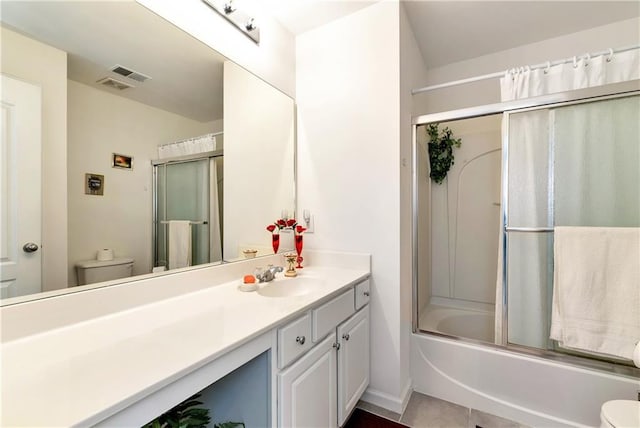 full bathroom featuring tile patterned floors, vanity, enclosed tub / shower combo, and toilet