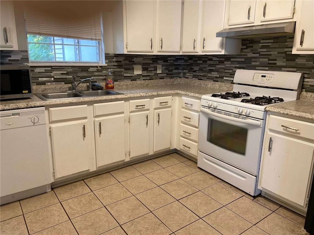 kitchen with under cabinet range hood, white appliances, a sink, and backsplash