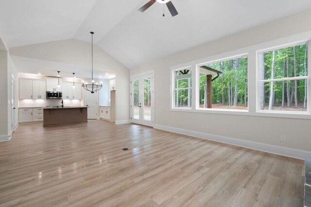 130 Doris Path, Dallas, GA 30157 - unfurnished living room with vaulted ceiling, a chandelier, ceiling fan, baseboards, and light wood-type flooring