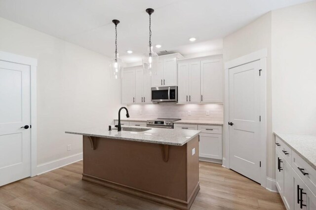 130 Doris Path, Dallas, GA 30157 - kitchen featuring stainless steel appliances, a sink, backsplash, white cabinets, and light wood finished floors