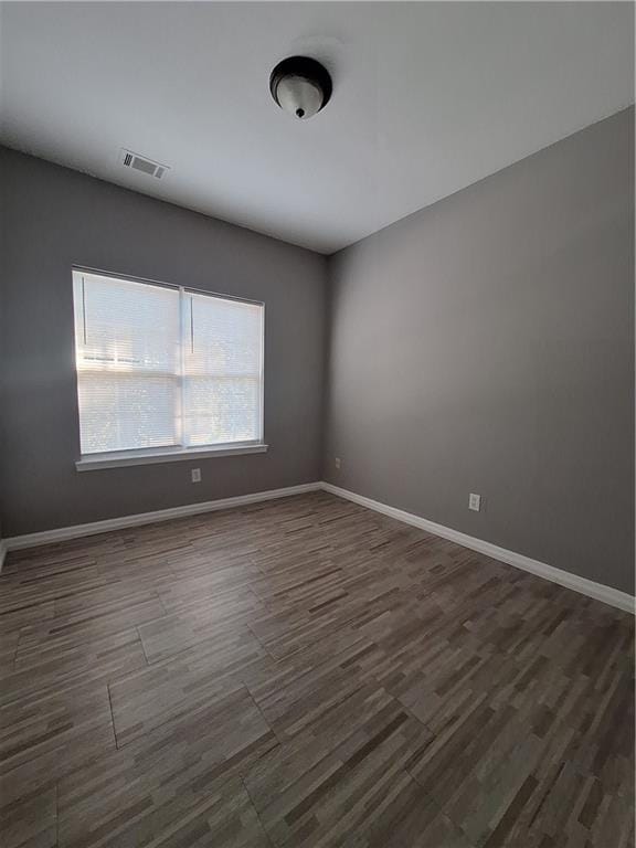 unfurnished room featuring dark wood-type flooring