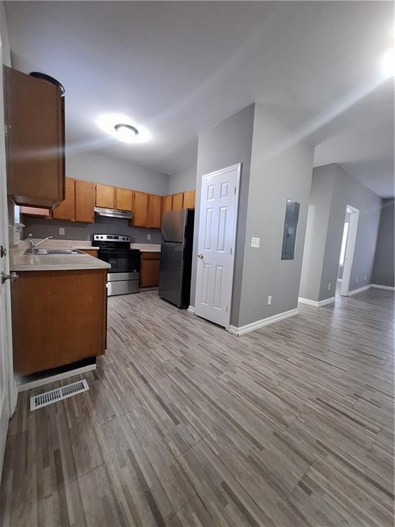 kitchen featuring light hardwood / wood-style floors, sink, refrigerator, and stainless steel range with electric stovetop