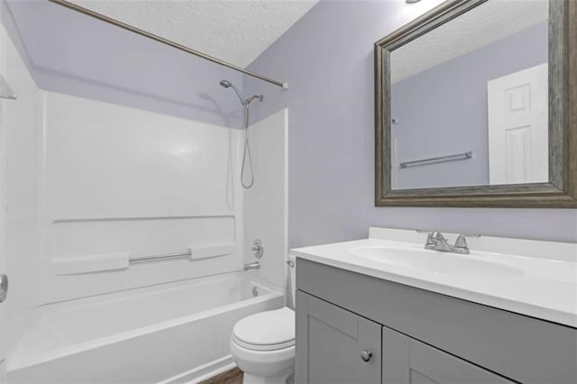 bathroom with vanity, a textured ceiling, bathing tub / shower combination, and toilet