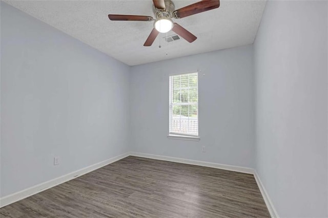 unfurnished room with visible vents, wood finished floors, and baseboards