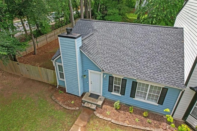 view of front of home featuring roof with shingles, a chimney, and a fenced backyard