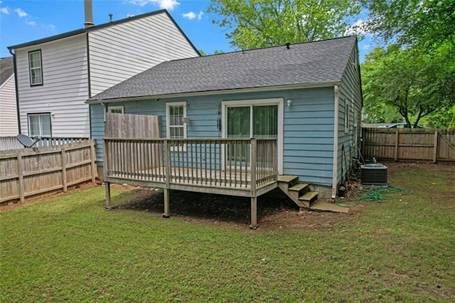 back of property with central AC, a yard, a fenced backyard, a wooden deck, and a shingled roof