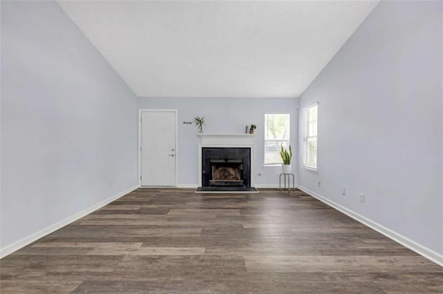 unfurnished living room featuring wood finished floors, baseboards, a fireplace, and lofted ceiling