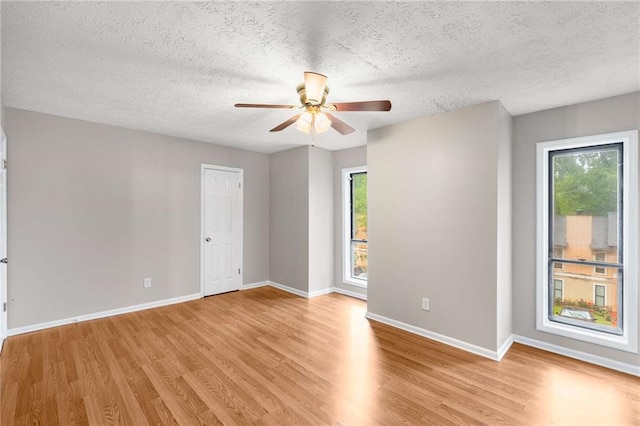 2340 Beaver Ruin Rd Unit 68, Norcross, GA 30071 - spare room featuring a textured ceiling, light wood-style flooring, plenty of natural light, and a ceiling fan