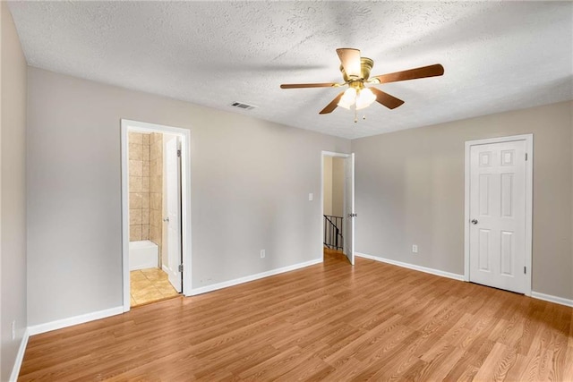 2340 Beaver Ruin Rd Unit 68, Norcross, GA 30071 - unfurnished bedroom with light wood-style floors, baseboards, a textured ceiling, ensuite bathroom, and a ceiling fan