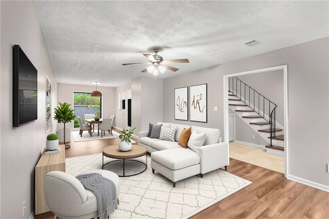 2340 Beaver Ruin Rd Unit 68, Norcross, GA 30071 - living room with wood finished floors, stairs, a ceiling fan, baseboards, and a textured ceiling