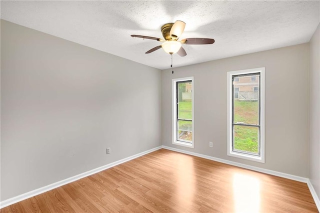 2340 Beaver Ruin Rd Unit 68, Norcross, GA 30071 - empty room featuring light wood finished floors, baseboards, ceiling fan, and a textured ceiling