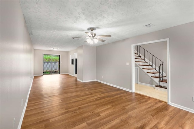 2340 Beaver Ruin Rd Unit 68, Norcross, GA 30071 - unfurnished room with wood finished floors, stairs, ceiling fan, a textured ceiling, and baseboards
