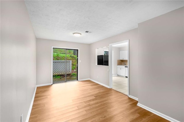 2340 Beaver Ruin Rd Unit 68, Norcross, GA 30071 - spare room with light wood-type flooring, baseboards, and a textured ceiling