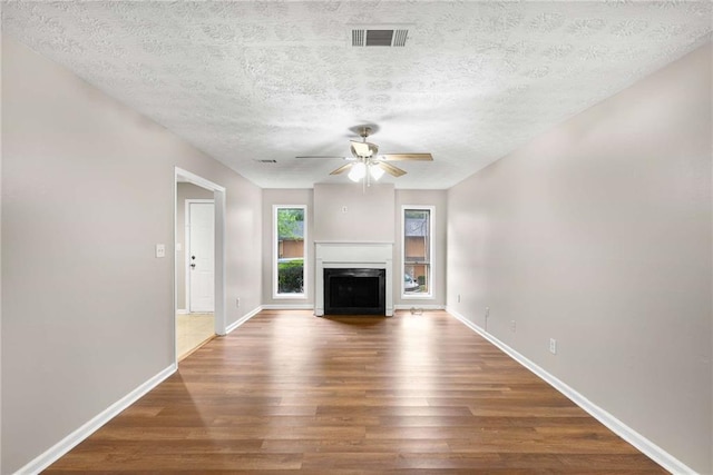 2340 Beaver Ruin Rd Unit 68, Norcross, GA 30071 - unfurnished living room with wood finished floors, ceiling fan, a fireplace, a textured ceiling, and baseboards