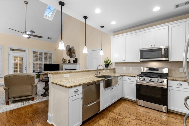 kitchen featuring stainless steel appliances, white cabinetry, and kitchen peninsula