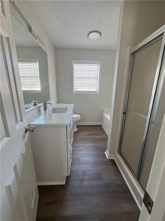 full bathroom with vanity, a shower stall, toilet, and wood finished floors