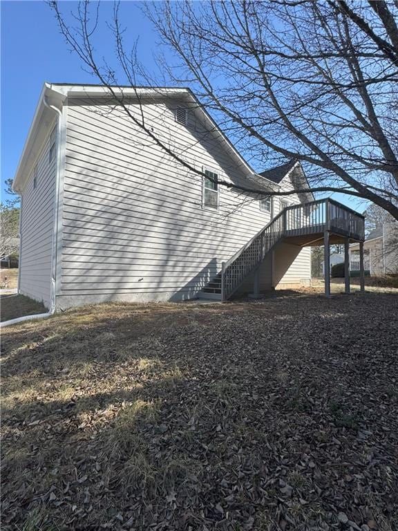 view of home's exterior with stairway and a deck