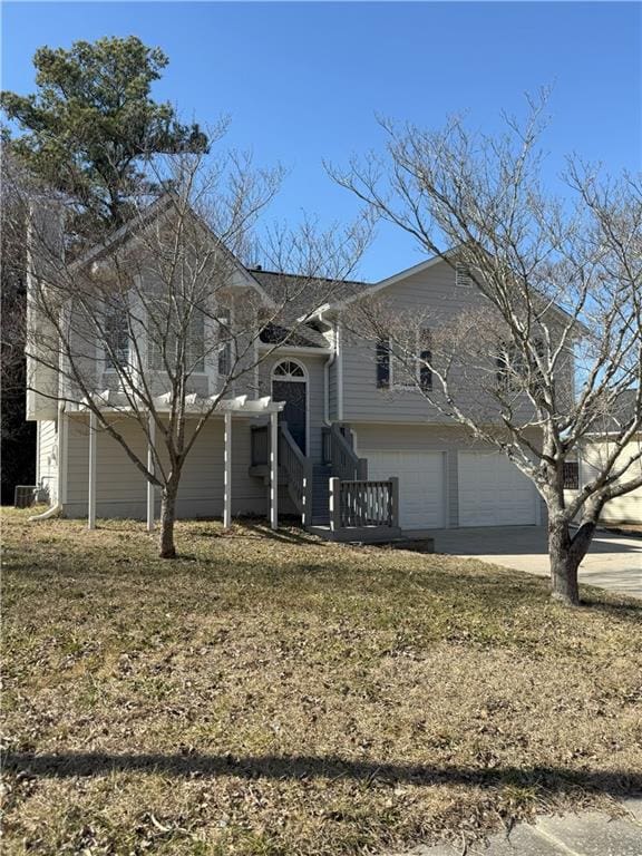 tri-level home featuring concrete driveway and a garage