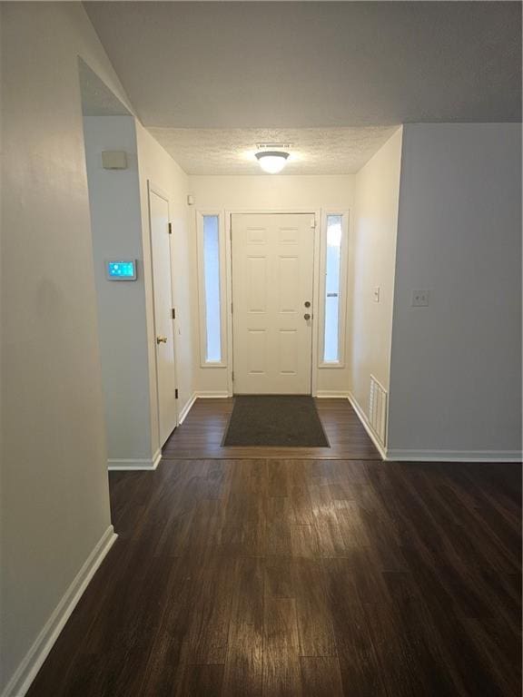 foyer entrance featuring dark hardwood / wood-style floors and a textured ceiling