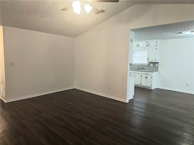 unfurnished living room featuring ceiling fan, lofted ceiling, dark hardwood / wood-style flooring, and sink