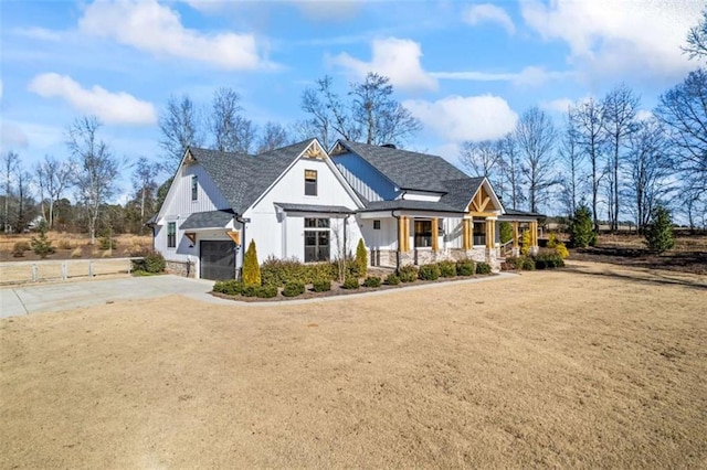 view of front of house with a porch, a garage, and a front lawn