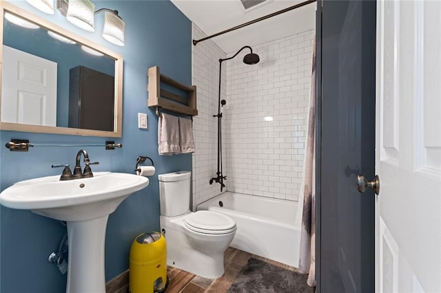 full bath featuring toilet, a sink, and shower / tub combo with curtain