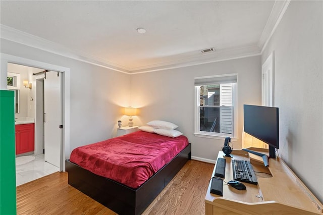 bedroom featuring baseboards, light wood-style flooring, visible vents, and crown molding