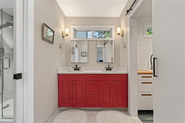 bathroom featuring a stall shower, a sink, and a wealth of natural light