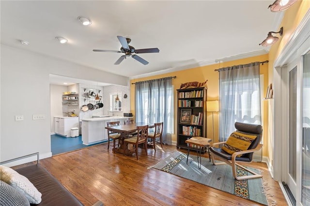 dining space with ceiling fan, wood finished floors, and baseboards