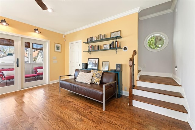 living area with crown molding, baseboards, and wood finished floors