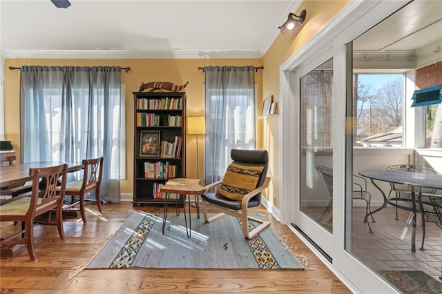 sitting room featuring ornamental molding, plenty of natural light, and wood finished floors