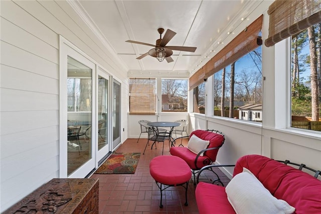 sunroom / solarium featuring a ceiling fan