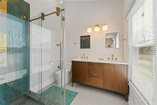 full bath featuring double vanity, tile patterned flooring, a sink, and a shower stall