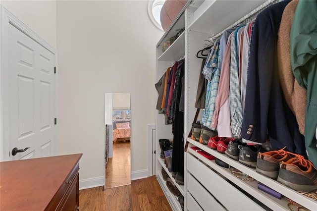 walk in closet with dark wood-type flooring