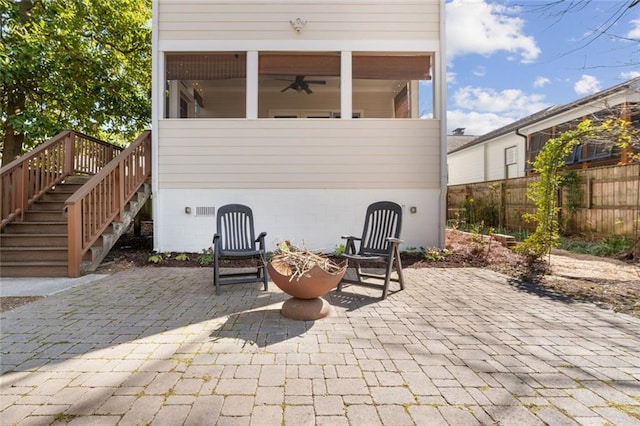 view of patio featuring stairs, fence, and a ceiling fan