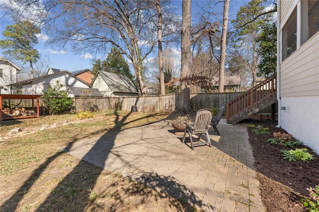 view of yard featuring stairs, a patio area, and a fenced backyard