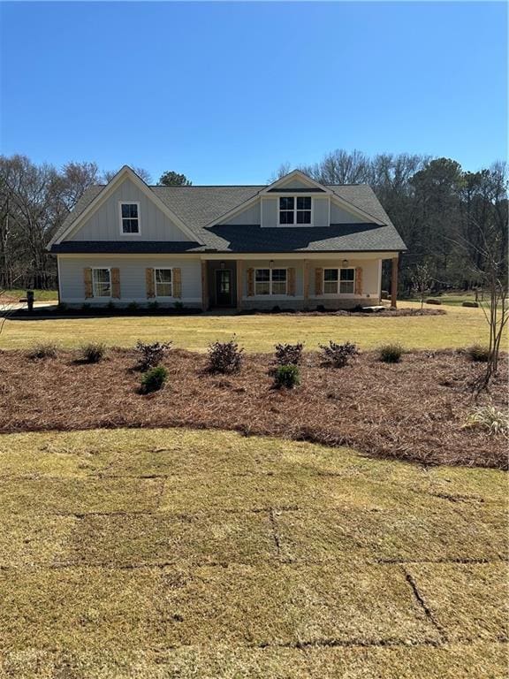 view of front facade featuring a front lawn, a porch, and board and batten siding