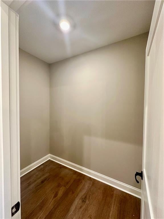 interior space with dark wood-type flooring and baseboards