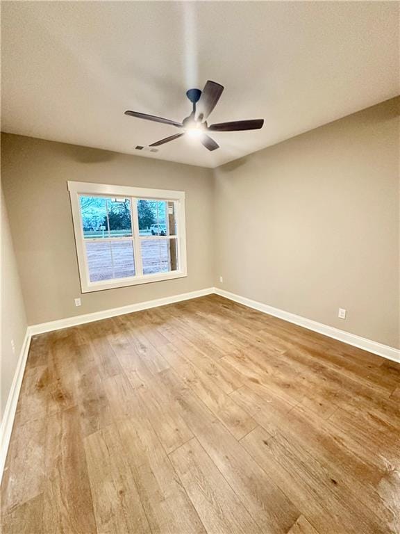 unfurnished room featuring ceiling fan, baseboards, and wood finished floors