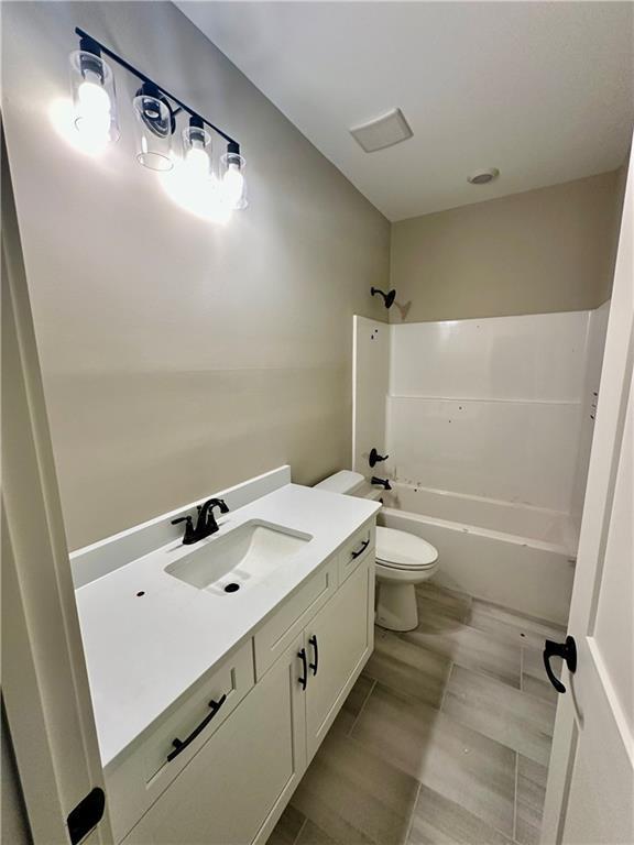 full bathroom with shower / washtub combination, toilet, and vanity