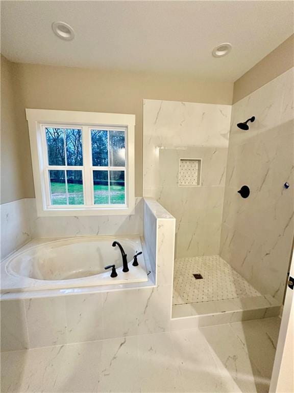 bathroom with a marble finish shower and a garden tub