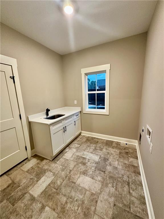 laundry area with baseboards, washer hookup, cabinet space, hookup for an electric dryer, and a sink