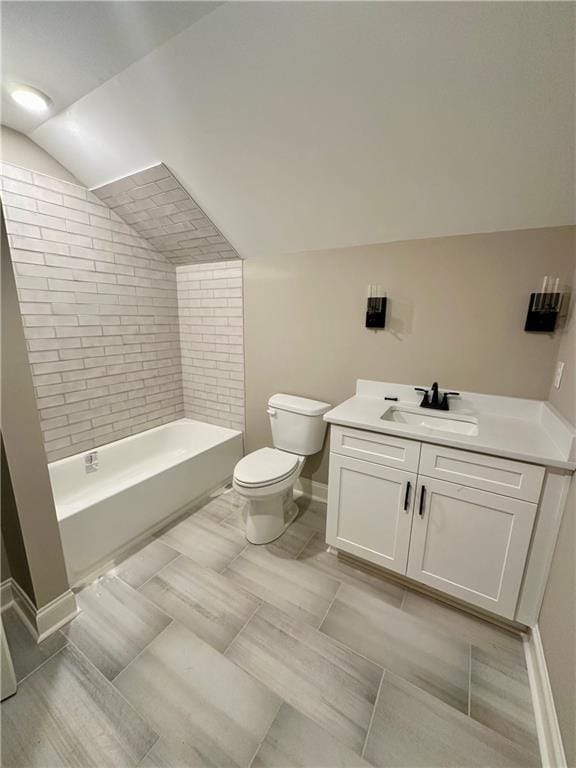 full bath with vanity, baseboards, vaulted ceiling, toilet, and shower / bathtub combination