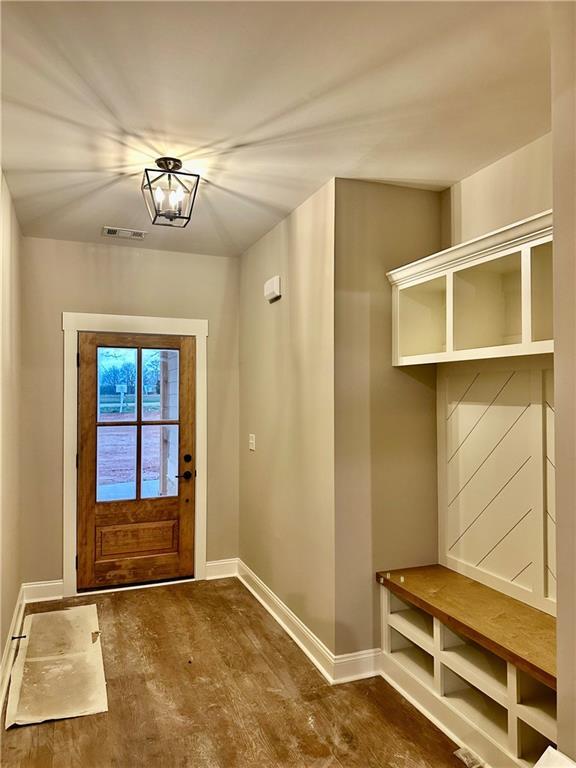 mudroom with visible vents, baseboards, and wood finished floors