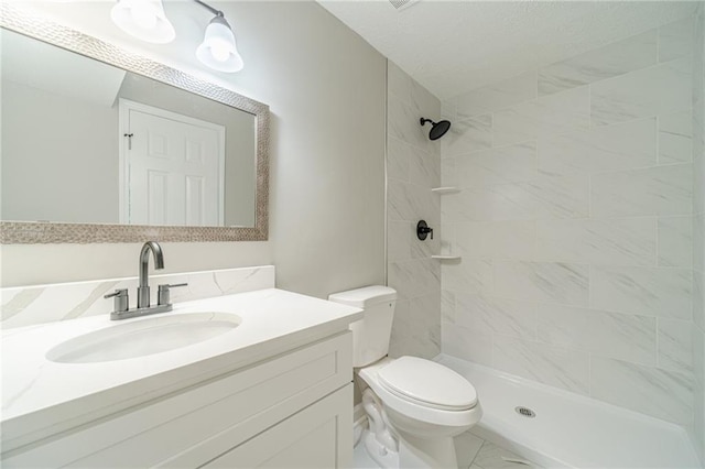 full bathroom featuring toilet, vanity, and tiled shower