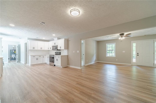 unfurnished living room with light wood finished floors, a textured ceiling, baseboards, a ceiling fan, and recessed lighting