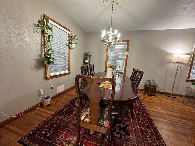 dining room with hardwood / wood-style flooring and a chandelier